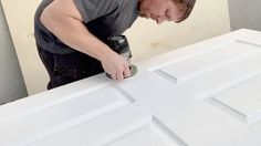 a man with a paint roller painting a white door