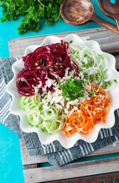 a white bowl filled with veggies on top of a wooden table