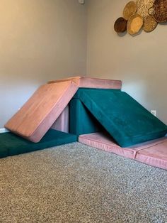 a pink and green slide in the corner of a room with carpeted flooring