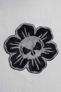 a black and white flower with a skull in the center on a white shirt background