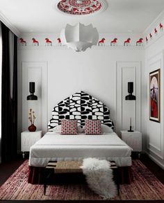 a bedroom with white walls and red accents on the ceiling, along with a black and white patterned headboard