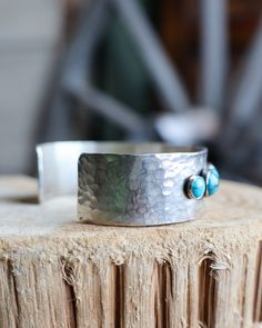 This timeless, handmade sterling silver cuff bracelet combines 5 medium and 6 small rounds of turquoise set in a beautiful hammered pattern for a look that radiates class and sophistication. Make a bold statement with Richard Schmidt's Turquoise 5 Medium 6 Small Rounds 3/4" Cuff! Width: 3/4" Materials: Turquoise, Sterling Silver Designer: Richard Schmidt Jewelry Handmade in La Grange, TX by designer Richard Schmidt and his son. Richard draws inspiration from the rich heritage and faith of his be Adjustable Hammered Turquoise Jewelry, Richard Schmidt, Textures And Tones, Hammered Sterling Silver, Sterling Silver Cuff Bracelet, Sterling Silver Cuff, Silver Cuff Bracelet, Silver Cuff, Handmade Sterling Silver