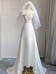 a white wedding dress on display in a room