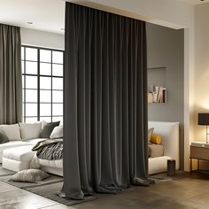 a living room with a white couch and black curtains