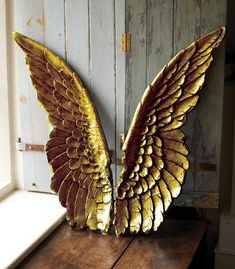 two golden wings are sitting on a wooden table