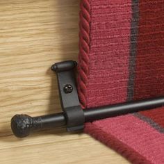 a close up of a red and black striped chair with a metal handle on it