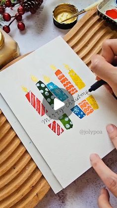 two hands are drawing on paper with colored pencils