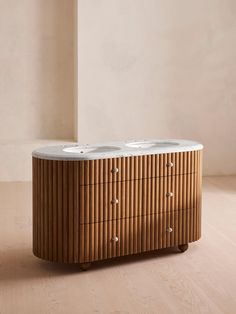 a wooden cabinet with two sinks on it's sides and a wall in the background