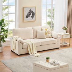 a living room filled with furniture and a white rug on top of a hard wood floor