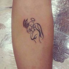 a small tattoo on the leg of a woman with an angel and heart in it