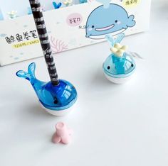 two blue and white whale shaped items on a table