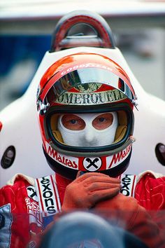 a man with a helmet on sitting in a race car