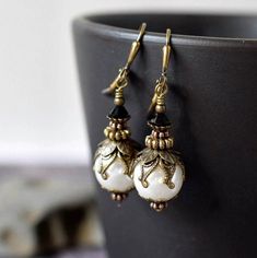 "Victorian Pearl Earrings, Long White Pearl Drops, Antique Brass, 1920s White & Black Goth Wedding . . . Romantic Neo Victorian Pearl Earrings handmade to look centuries-old with a vintage appeal from a bygone era. Graceful jet black crystals sit on top of layers of 1920s vintage style antique brass bead caps adorning the Czech glass white pearl drops. These pearl drops are shown from antique brass shield lever back ear wires. The hypoallergenic lever back ear wires are plain style. Make a grand Vintage Black Jewelry With Antique Finish, Victorian Wedding Earrings With Antique Finish, Elegant Black Jewelry With Antique Finish, Vintage Black Earrings For Wedding, Vintage Black Jewelry With Matching Earrings, Vintage Wedding Earrings With Antique Finish, Black Nickel-free Earrings For Wedding, Nickel-free Black Earrings For Wedding, Nickel-free Black Wedding Earrings