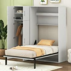 a white bed sitting next to a wall with a book shelf on top of it