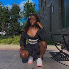 a woman sitting on the ground in front of a building