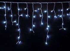 some lights are hanging from a string in the dark