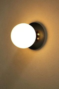 a light that is on the side of a wall with a white ball in it