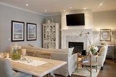 a living room filled with furniture and a flat screen tv mounted above a fire place