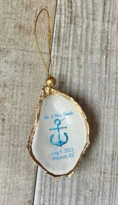 an ornament hanging from a wooden table with a blue and white anchor on it