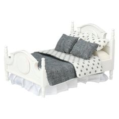 a white bed with polka dot pillows and blankets on it's headboard, in front of a white background