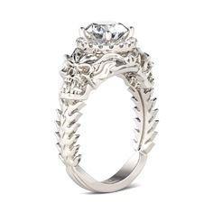 a white gold engagement ring with an intricate floral design on the band and center stone