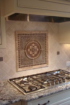 a stove top oven sitting inside of a kitchen next to a wall mounted tile mural