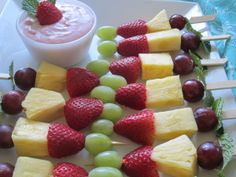 fruit skewers are arranged on a white plate