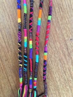 multicolored beaded necklaces with tassels and beads on wooden surface