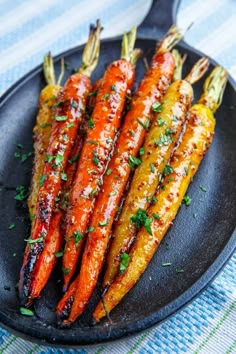 grilled carrots on a black plate with parsley