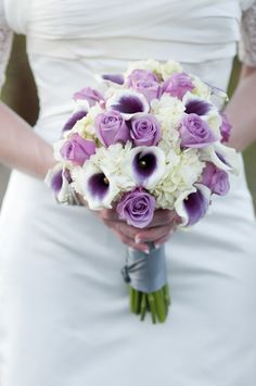 the bride's bouquet is purple and white