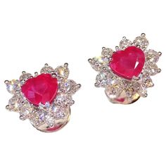 Burmese rubies are sought after for their beautiful red tones. These 18k white gold earrings featuring a 2.23 carat rare heart-shaped ruby is a great example of the Burmese allure - deep red tones with the slightest hint of purple. Halo set with round brilliant-cut diamonds, the total diamond weight for the piece is 1.30 carats. The earring weighs 4.72 grams. The rubies are highly saturated in color . Accompanied by IGI report #10J1307620 stating natural ruby with Burmese origin. Burmese Ruby, Halo Setting, White Gold Earrings, Natural Ruby, Burmese, Round Brilliant Cut Diamond, Deep Red, Jewelry Earrings Studs, Gold Earrings