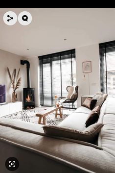 a living room filled with furniture and a flat screen tv mounted on a wall next to a fire place