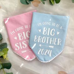 two blue and pink bibs with the words i'm going to be a big brother