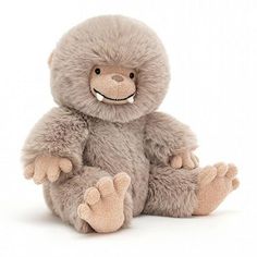 a stuffed slotty bear sitting on the ground with its paws out and eyes wide open