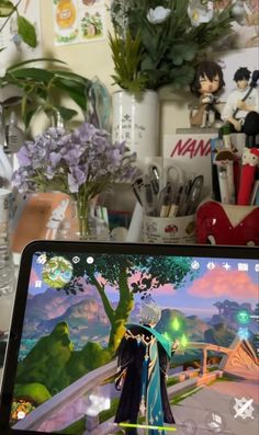 a cell phone with an anime scene on the screen next to flowers and other items