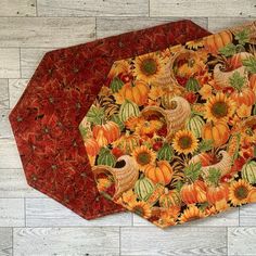 two pieces of fabric with pumpkins and sunflowers on them