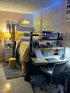 a bedroom with a bed, desk and computer