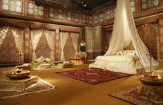 a large bed sitting inside of a bedroom next to a white canopy over a doorway