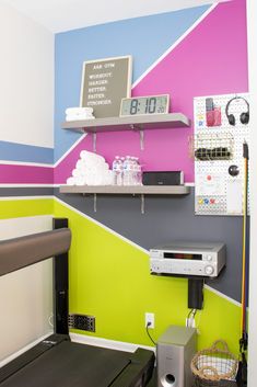 a room with a bed, television and shelves on the wall above it that have various items