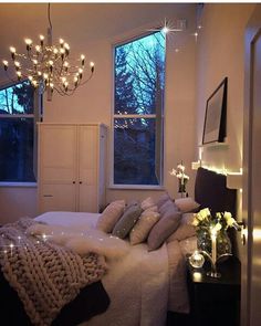 a bedroom with a bed, chandelier and lights on the wall above it