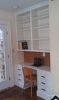 a desk with a laptop computer on top of it next to a book shelf and door