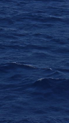 a man riding a surfboard on top of a large body of water in the ocean