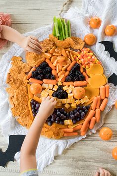 a halloween snack board with jack - o - lantern faces made out of fruit and veggies