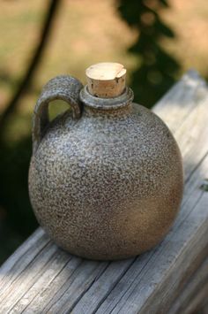 a brown vase sitting on top of a wooden bench