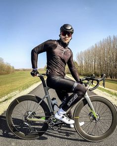 a man riding on the back of a bike down a road