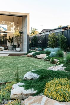 an outdoor area with grass, rocks and plants