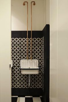 a black and white tiled bathroom with gold faucets on the wall above it