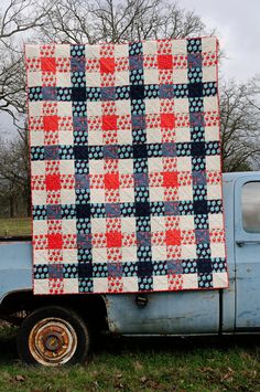 an old pick up truck with a quilt on the back