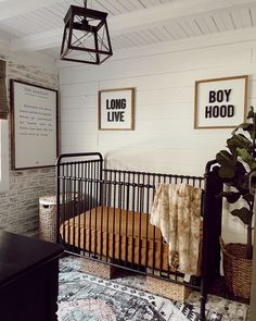 a baby crib in the corner of a room with two pictures on the wall