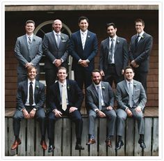 a group of men in suits and ties posing for a photo on the steps outside